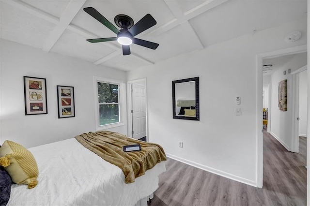 bedroom with coffered ceiling, ceiling fan, hardwood / wood-style flooring, and beamed ceiling