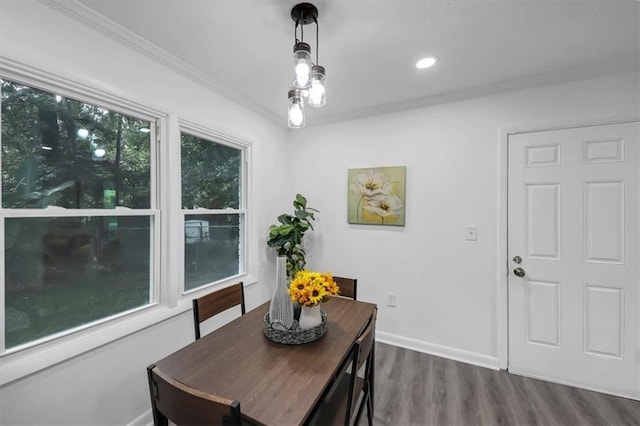 dining space with dark hardwood / wood-style flooring and crown molding