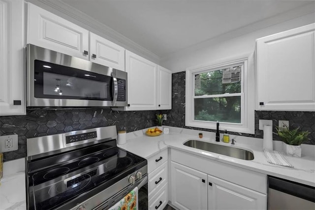 kitchen featuring white cabinets, appliances with stainless steel finishes, tasteful backsplash, and sink