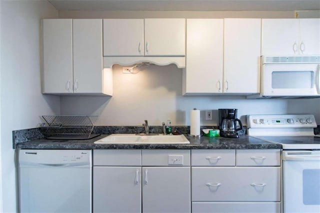 kitchen featuring sink, white appliances, and white cabinetry