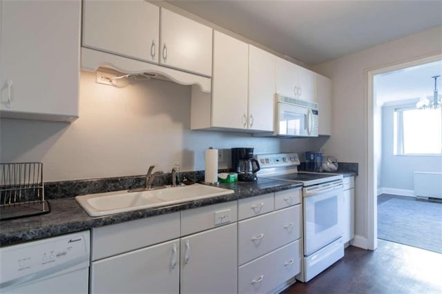 kitchen featuring dark wood-type flooring, sink, white cabinets, and white appliances