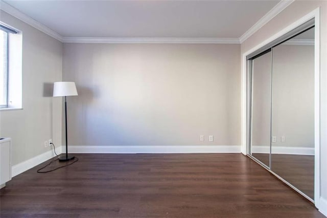 unfurnished bedroom featuring a closet, dark hardwood / wood-style flooring, and ornamental molding