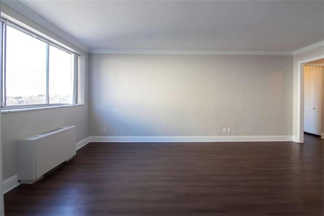 spare room with radiator, dark hardwood / wood-style floors, and ornamental molding