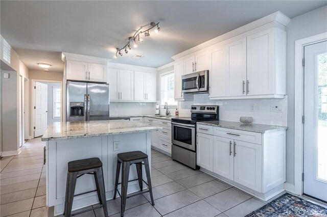 2010 2nd Ave, Decatur, GA 30032 - kitchen featuring appliances with stainless steel finishes, backsplash, a kitchen bar, and white cabinets