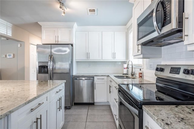2010 2nd Ave, Decatur, GA 30032 - kitchen featuring appliances with stainless steel finishes, white cabinetry, backsplash, light tile patterned flooring, and light stone counters