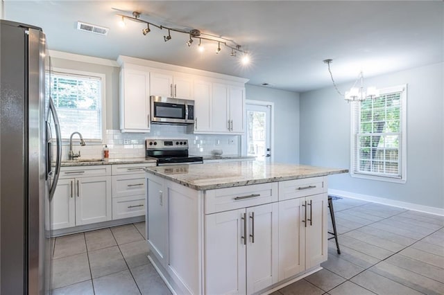 2010 2nd Ave, Decatur, GA 30032 - kitchen featuring appliances with stainless steel finishes, light tile patterned floors, tasteful backsplash, a kitchen island, and a chandelier