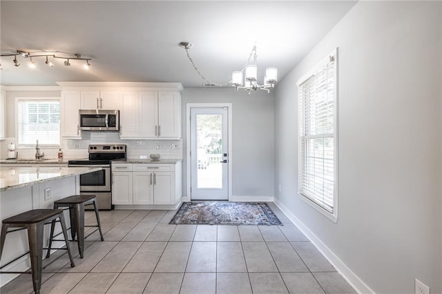 2010 2nd Ave, Decatur, GA 30032 - kitchen featuring stainless steel appliances, a chandelier, backsplash, light tile patterned flooring, and white cabinetry