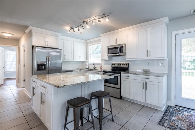 2010 2nd Ave, Decatur, GA 30032 - kitchen with stainless steel appliances, a kitchen island, a kitchen breakfast bar, and light tile patterned flooring