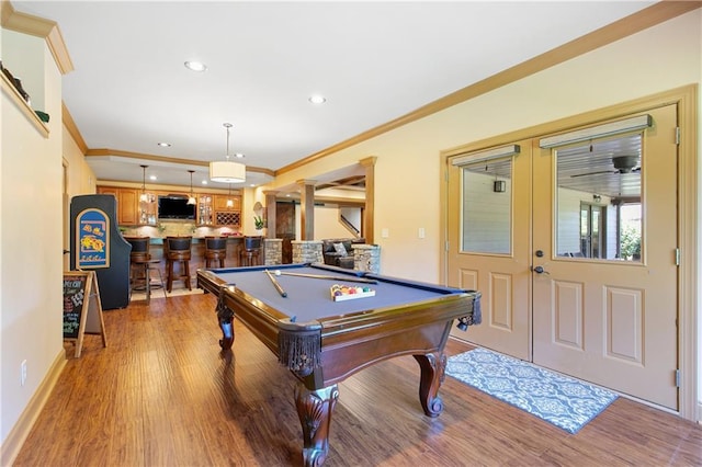 playroom featuring bar, ornamental molding, pool table, and wood-type flooring