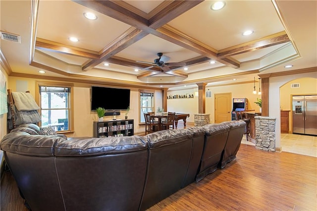 living room with ceiling fan, light wood-type flooring, crown molding, and coffered ceiling