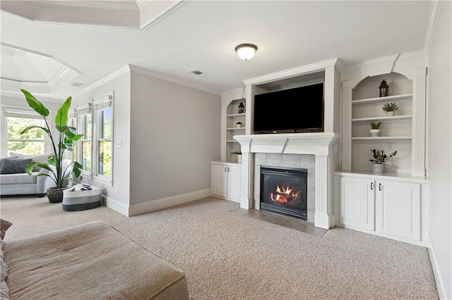 carpeted living room featuring built in features, crown molding, and a tiled fireplace