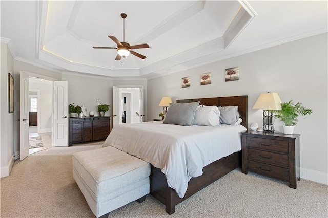 carpeted bedroom with ceiling fan, crown molding, and a raised ceiling