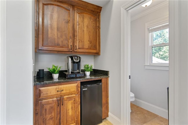 bar featuring light tile patterned floors, dishwasher, ornamental molding, and dark stone countertops