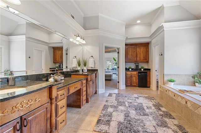 bathroom with tiled tub, tile patterned floors, and vanity