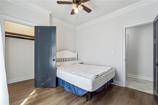 bedroom with crown molding, baseboards, and wood finished floors