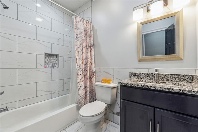 bathroom with vanity, marble finish floor, toilet, shower / bathtub combination with curtain, and a wainscoted wall