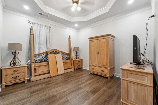 bedroom with ceiling fan, visible vents, a raised ceiling, dark wood-style floors, and ornamental molding