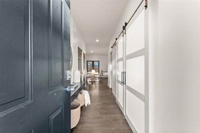 hallway featuring dark hardwood / wood-style floors and a barn door