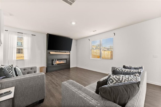 living room with dark hardwood / wood-style floors and a wealth of natural light