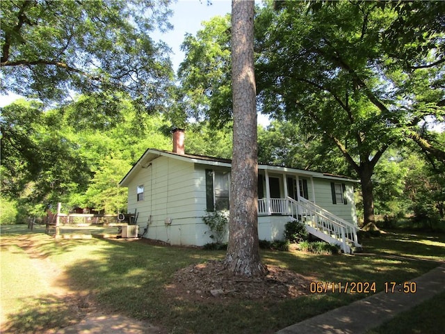 view of front of house with cooling unit and a front yard