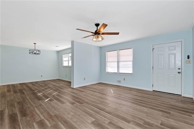 interior space with ceiling fan with notable chandelier, hardwood / wood-style flooring, and a wealth of natural light