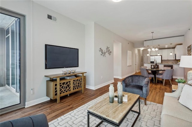 living room with light hardwood / wood-style flooring and an inviting chandelier