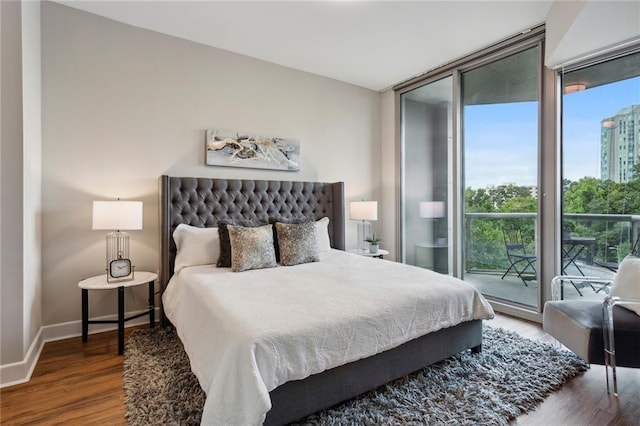 bedroom with access to outside, floor to ceiling windows, and hardwood / wood-style flooring