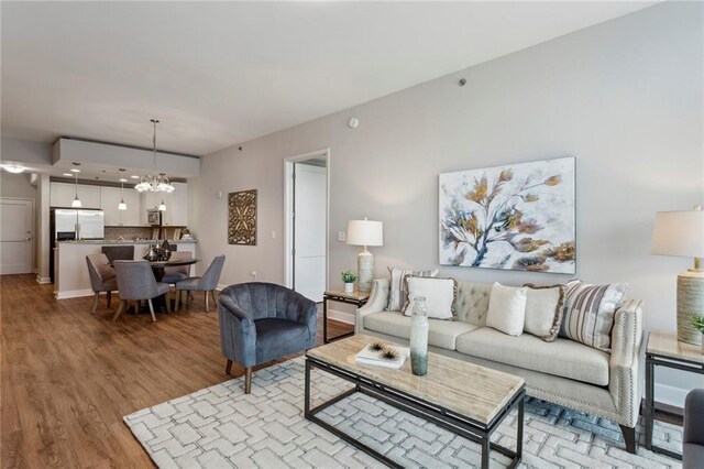 living room featuring a notable chandelier and light wood-type flooring