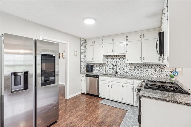 1752 Shadybrook Ct, Lawrenceville, GA 30043 - kitchen with appliances with stainless steel finishes, a sink, dark wood-style flooring, tasteful backsplash, and white cabinets