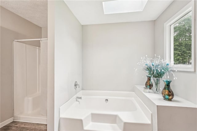 1752 Shadybrook Ct, Lawrenceville, GA 30043 - bathroom featuring a skylight, wood finished floors, a bath, and a shower