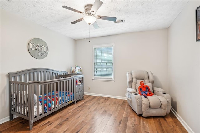 1752 Shadybrook Ct, Lawrenceville, GA 30043 - bedroom with hardwood / wood-style floors, a textured ceiling, baseboards, and a nursery area