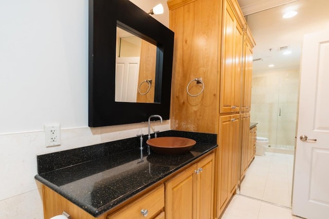 bathroom featuring toilet, an enclosed shower, vanity, and tile patterned floors