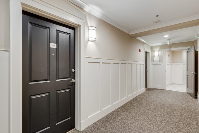 hall featuring ornamental molding and light colored carpet