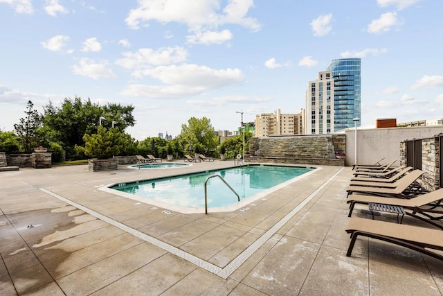 view of pool featuring a patio and a hot tub