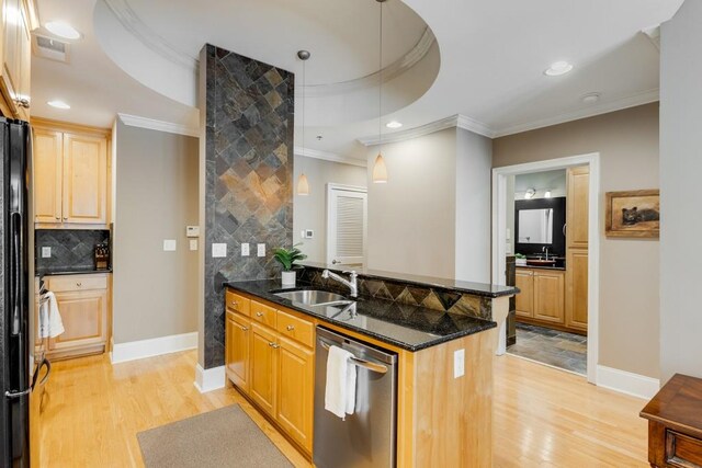 kitchen featuring sink, a raised ceiling, decorative light fixtures, stainless steel dishwasher, and light hardwood / wood-style flooring