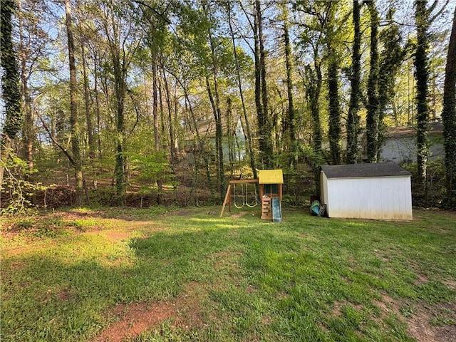 view of yard with a shed, a playground, and an outbuilding