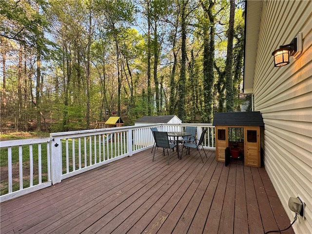 wooden terrace with an outbuilding and outdoor dining area