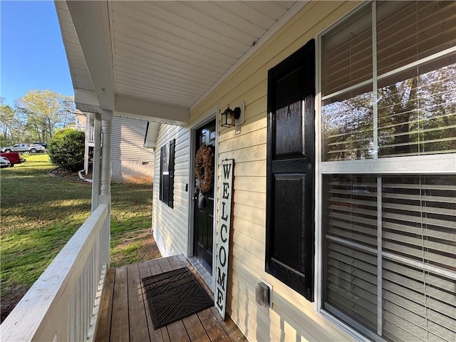 wooden deck featuring a yard and covered porch
