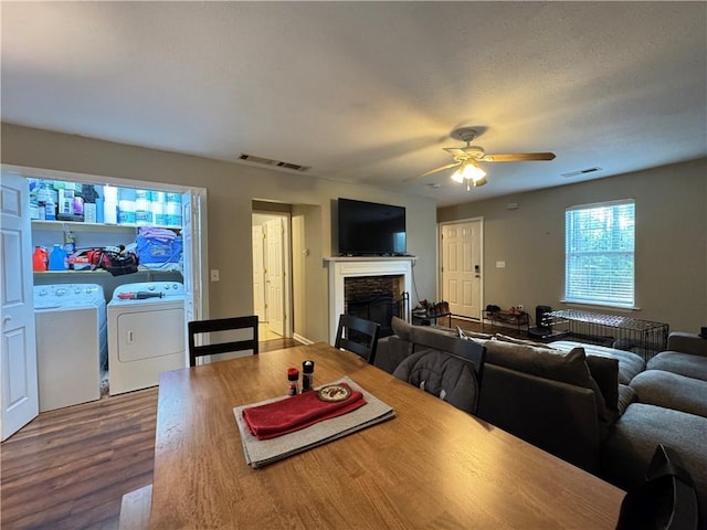 living room with visible vents, washer and clothes dryer, a ceiling fan, and dark wood finished floors