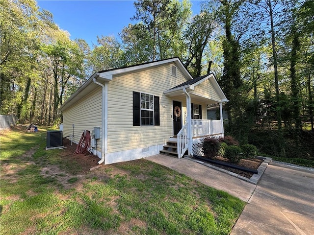 view of front of property featuring central AC, a front lawn, covered porch, and crawl space