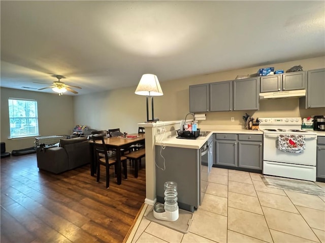 kitchen featuring light countertops, gray cabinetry, electric range, and under cabinet range hood
