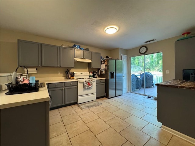 kitchen with visible vents, under cabinet range hood, stainless steel fridge, electric stove, and gray cabinetry