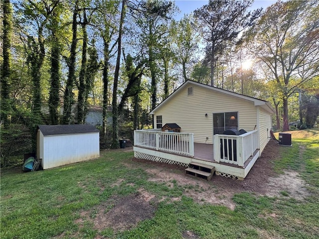 rear view of property featuring an outbuilding, a wooden deck, a lawn, and a storage unit