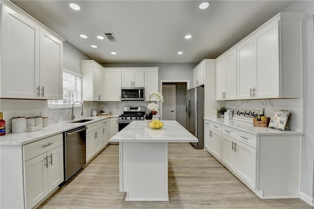 kitchen featuring white cabinetry, appliances with stainless steel finishes, sink, and a kitchen island