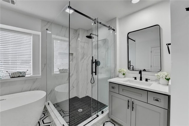 bathroom with vanity, shower with separate bathtub, and tile walls