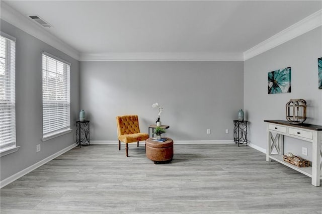 sitting room featuring ornamental molding and light hardwood / wood-style floors