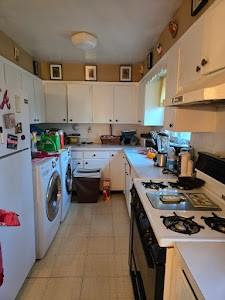 kitchen with white cabinets, white appliances, extractor fan, and washer and clothes dryer