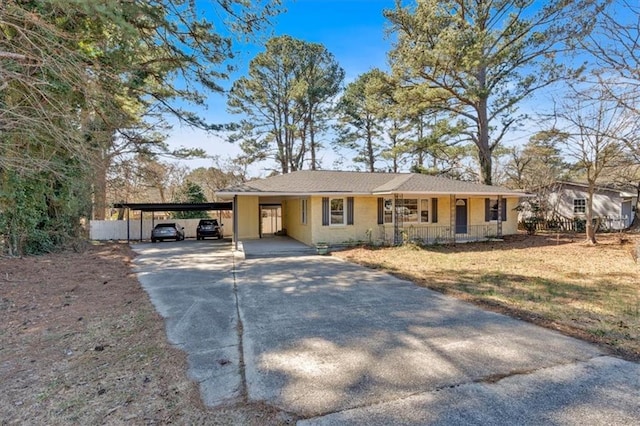 single story home with a porch, an attached carport, and concrete driveway