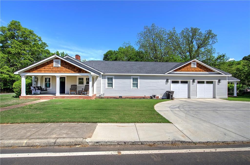 119 Cassville Rd, Cartersville, GA 30120 - craftsman house featuring a front lawn, driveway, a chimney, covered porch, and an attached garage