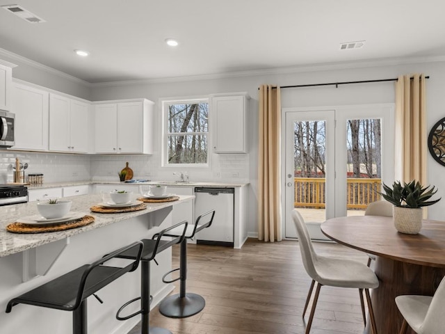 kitchen with white cabinets, a healthy amount of sunlight, and appliances with stainless steel finishes